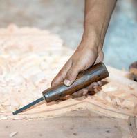 close-up carpenter man's hand treats the tree, cuts the shavings. Copy space. woody curl. Manual processing of wood in the workshop. joiner woodworker in process. photo