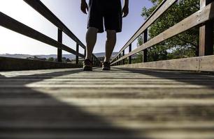 Man's feet on wooden walkway photo