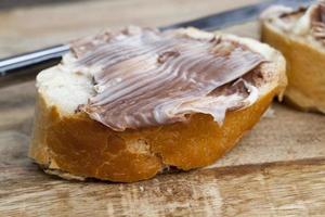 sliced white bread with sweet chocolate butter spread photo