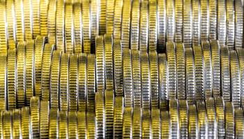 many round metal coins of silver color illuminated in yellow photo