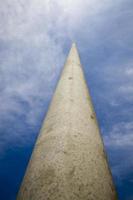 long concrete electric pole against the blue sky, close up photo