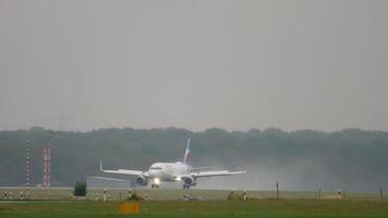 DUSSELDORF, GERMANY JULY 24, 2017 - Eurowings Airbus 320 D AEWL braking after landing at rain. Dusseldorf airport video