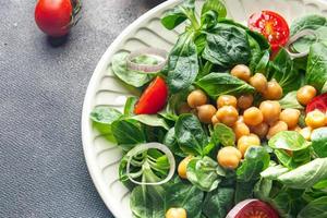 salad chickpeas, legumes, lettuce, mache, tomato fresh healthy meal food snack diet on the table copy space food background rustic top view keto or paleo diet veggie vegan or vegetarian food photo