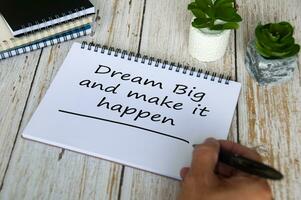 Dream big and make it happen text written on notepad. Motivational concept. photo