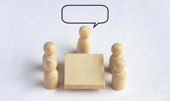 Wooden people figures having business meeting with customizable bubble spare for text or ideas. photo