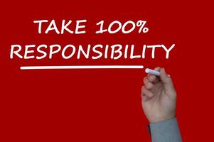 tome una nota de recordatorio de responsabilidad del 100 por ciento escrita en un fondo de cubierta roja. concepto de responsabilidad foto