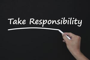 Take 100 percent responsibility reminder note written on blackboard. Responsibility concept photo