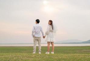 Happy young Asian couple in bride and groom clothing photo