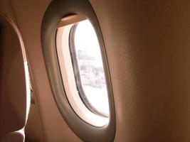 Typical airplane window from passenger seat view and dark background for wallpaper dreaming atmosphere concept photo