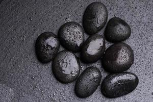 guijarros negros de textura para piedras de fondo o rocas y gotas de agua. foto