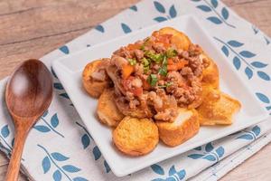 Fried tofu stir fried with ground pork and vegetables in white plate photo