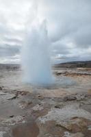 Blowing and Steaming Strokkur Blow Hole in Iceland photo