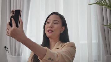 close-up video van een vrouw die een mobiele telefoon gebruikt om te videobellen met een collega.