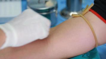 técnico de laboratório segurando a amostra do tubo de sangue para estudo, picando a seringa de agulha no braço paciente coletando amostra de sangue para exame de sangue. video