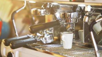 Close up coffee preparing in white ceramic cup from automatic coffee maker machine. video