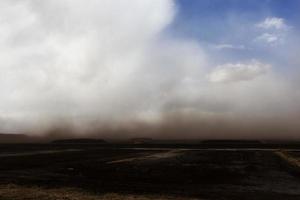 dust from peat excavations flying against the sky photo