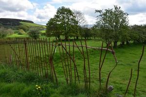 Bent and Broken Iron Rod Fence Around a Field photo