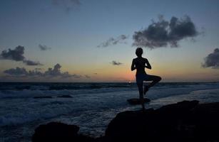 Silhouetted Tree Pose with Rising Sun photo