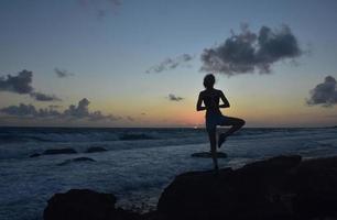 Yoga Tree Pose Silhouetted at Sunrise in Aruba photo