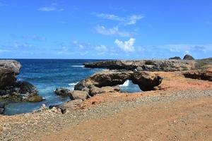 costa rural escarpada con un puente natural en aruba foto