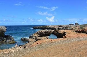 puente natural de roca de lava en la costa de aruba foto