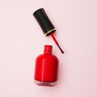 Red nail polish bottle laying on light pink background top view 3d illustration photo