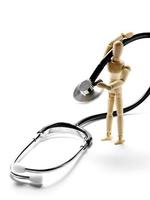 Wooden mannequin holding a stethoscope photo