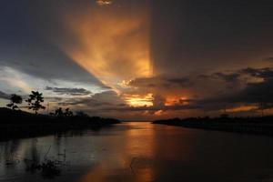 colorido cielo dramático con nubes al atardecer. puesta de sol en el lago foto