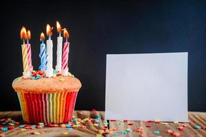 cupcake con velas festivas sobre fondo de madera foto