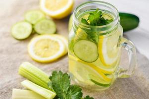 vaso de agua detox con limón, pepino y apio foto