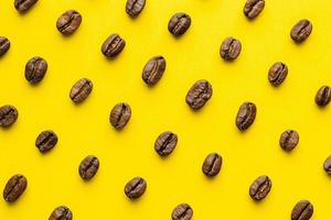 Coffee beans pattern on yellow background photo