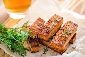 Rye croutons with dill and a glass of beer photo