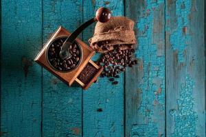 Vintage coffee grinder.Old retro hand-operated wooden and metal coffee grinder.Manual coffee grinder for grinding coffee beans. on the old wooden background.soft focus. photo