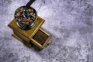 Vintage coffee grinder.Old retro hand-operated wooden and metal coffee grinder.Manual coffee grinder for grinding coffee beans. on the on the old stone floor. photo