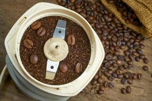 de cerca en un molinillo de café eléctrico con granos de café. efecto de enfoque superficial. enfoque suave. foto