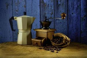 juego de café con cafetera moka y molinillo en el viejo piso de madera. enfoque suave. foto