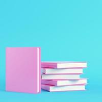 Pink stack of books on bright blue background in pastel colors photo