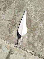 origami kunai on a gray wall background  handmade paper origami for children games photo