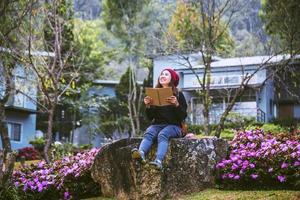 woman travel nature in the flower garden. relax sitting on rocks and reading books In the midst of nature at doi Inthanon. photo