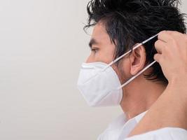 Asian young man in white shirt and medical mask to protect COVID-19 photo