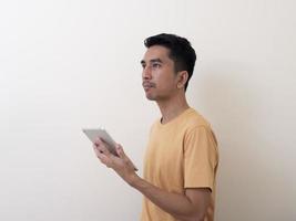 joven sosteniendo una tableta digital contra el fondo blanco foto