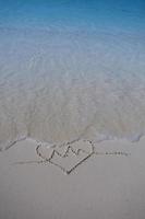 hearts drawn on the sand of a beach photo