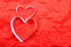 Paper hearts on red background photo