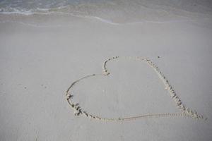 hearts drawn on the sand of a beach photo