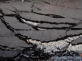 Cracked surface of an asphalt road photo