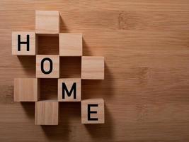 HOME concept with wooden block on wooden photo