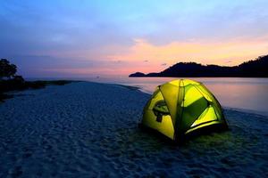 green tent on beach in sunset photo