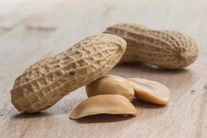 peanuts in shells over wood background photo