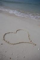 hearts drawn on the sand of a beach photo