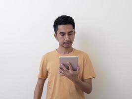 Young Man Holding Digital Tablet Against White Background photo